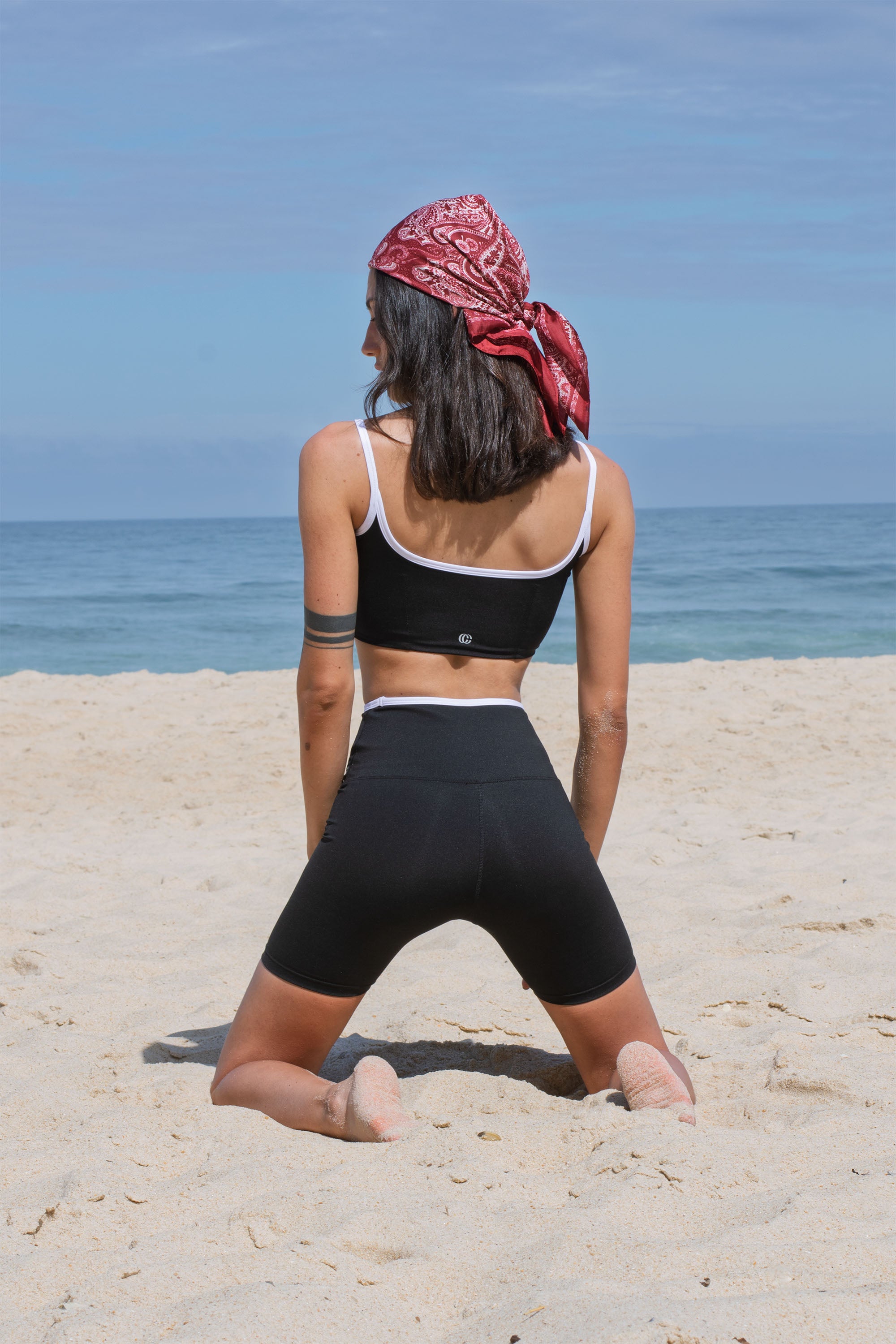 Casemiri Muiri set corto donna Black Mirage vista posteriore in ginocchio sulla sabbia